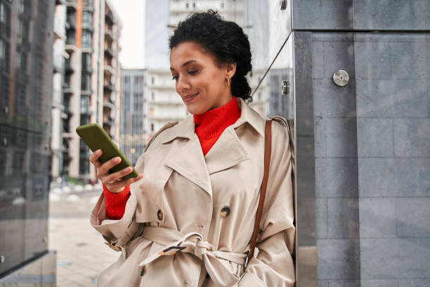 istock Multiracial woman using smartphone at the street while checking emails or messaging 1356323151