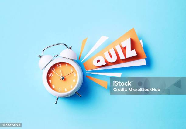 Quiz Word Sitting Next To A White Alarm Clock On Blue Background Stock Photo - Download Image Now