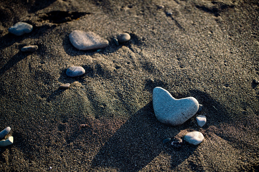 Heart shaped stone in the sandy beach
