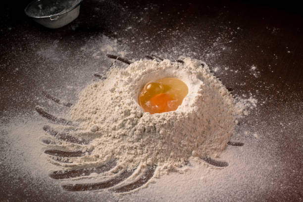 istock Flour with egg on the table. Dough preparation. 1356325282