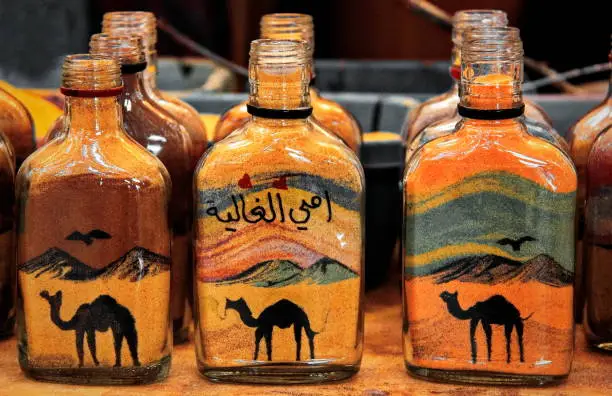 Photo of Arabian style souvenirs with multicolored sand in bottles, Jordan