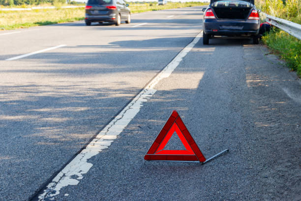 istock Red emergency stop sign (red triangle warning sign) and broken car on road 1356325336