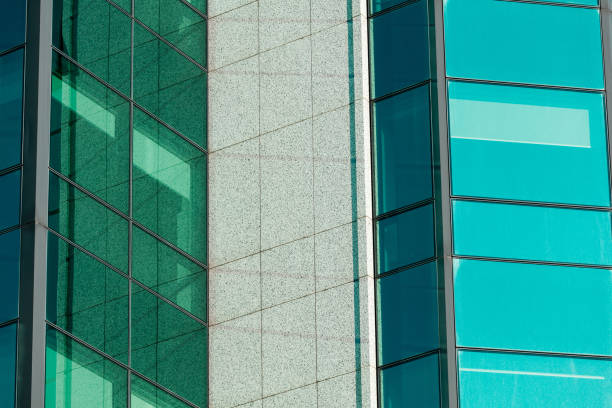 istock Turquoise colored glass and concrete building facade 1356326377