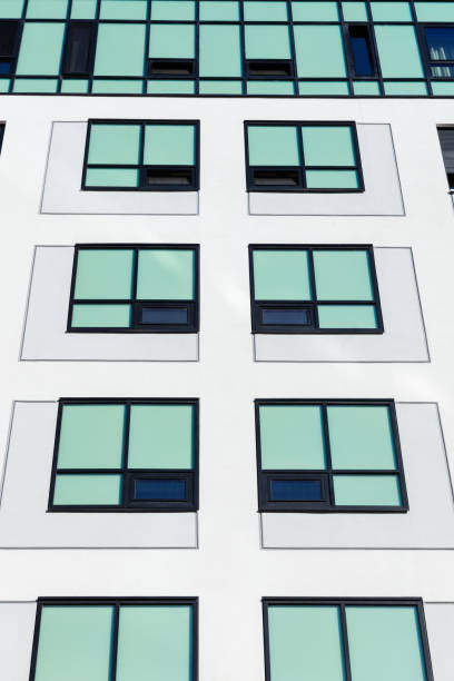 istock White concrete building facade with turquoise colored windows 1356326394