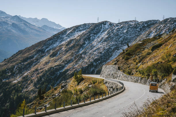 single old yellow van coming down the grimsel pass road in switzerland high angle view on single old yellow van coming down the winding road of grimsel pass in the swiss alps grimsel pass photos stock pictures, royalty-free photos & images
