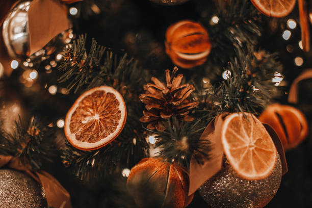istock Creative Christmas tree decorated with dry oranges and pine cones. Magic cozy details and golden bokeh lights on background. 1356328077