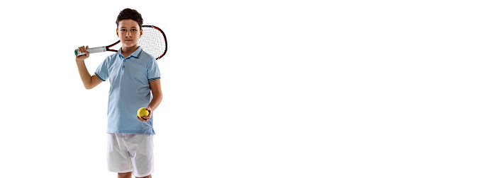 Portrait of boy, tennis player in uniform with racket posing isolated over white background. Concept of action, sport, healthy life, competition, motion, physical activity. Copy space for ad