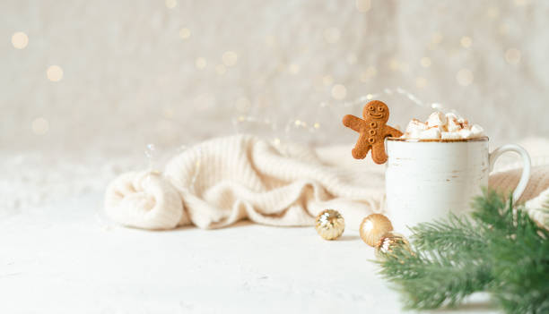 Gingerbread man cookie in cup of hot cocoa or coffee with marshmallow, fir tree, cinnamon and warm cozy sweater. Christmas banner, lights background. Xmas holiday decorations with copy space Gingerbread man cookie in cup of hot cocoa or coffee with marshmallow, fir tree, cinnamon and warm cozy sweater. Christmas banner, lights background. Xmas holiday decorations with copy space. hygge stock pictures, royalty-free photos & images