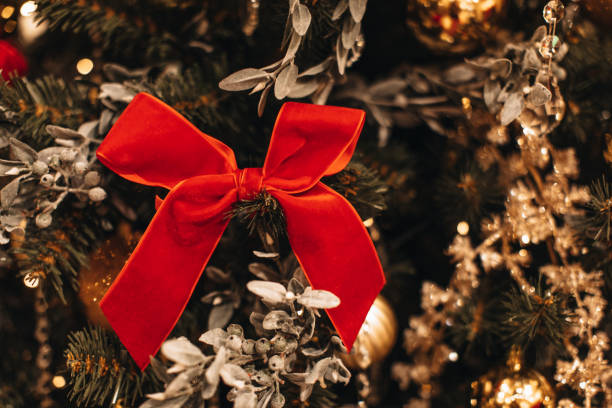 arco de veludo vermelho pendurado na árvore de natal. linda decoração de natal. - bow christmas red velvet - fotografias e filmes do acervo