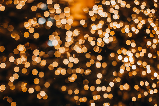 Golden Christmas bokeh lights background. Xmas abstract glowing decorations.