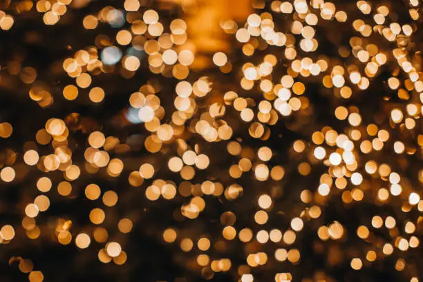 Photo of Golden Christmas bokeh lights background. Xmas abstract glowing decorations.