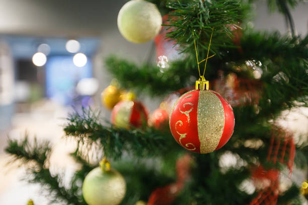 istock Closeup of red bauble hanging from a decorated Christmas tree 1356332615