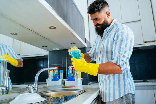 istock Young man washing dishes at home 1356333141