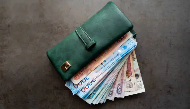 Russian money. Close-up of a green wallet full of 5000, 2000, 1000, 500 rubles banknotes. The money is in your wallet.