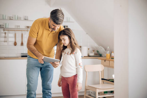 istock Man and his little daughter  using a smart system at their house 1356338785