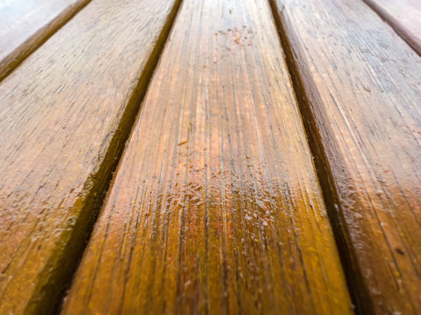 istock Wet light wood of a garden table. 1356339979