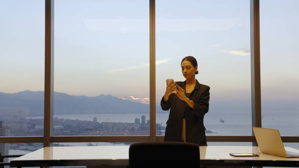 istock Businesswoman using mobile phone in modern office 1356342117