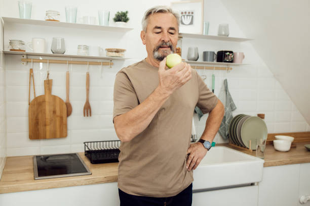 istock Portrait of a senior man snacking an apple 1356343371