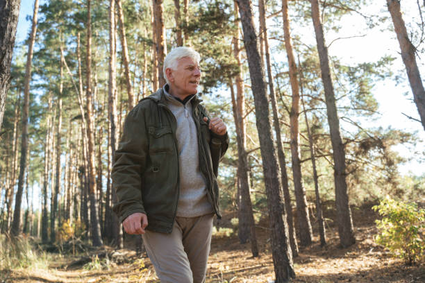 istock Thoughtful senior man feeling calm and peaceful while hiking in nature with backpack 1356343592