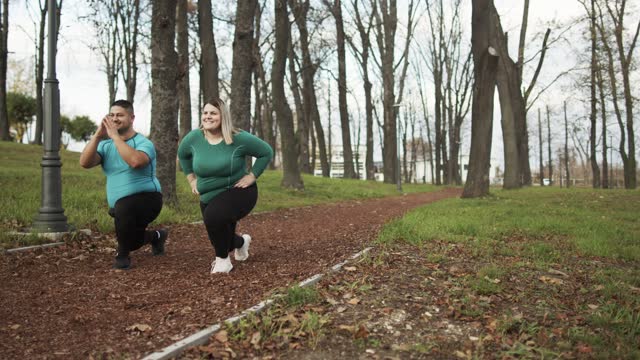 People with overweight problem exercising in city park