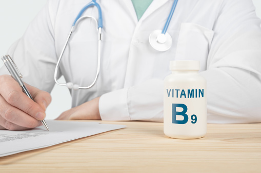Vitamin B9 and supplements for human health. Doctor recommends taking vitamin B9. doctor talks about Benefits of vitamin B9. Essential vitamins and minerals for humans. B Vitamin Health Concept.