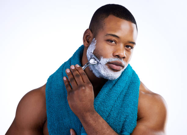 istock Studio portrait of a handsome young man shaving against a white background 1356344353