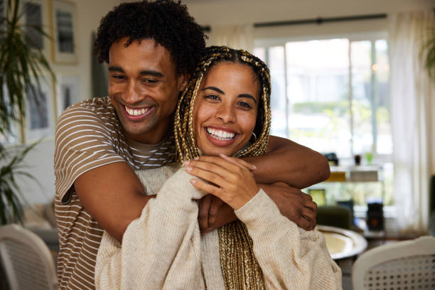 istock Affectionate young man hugging his smiling girlfriend at home 1356345714