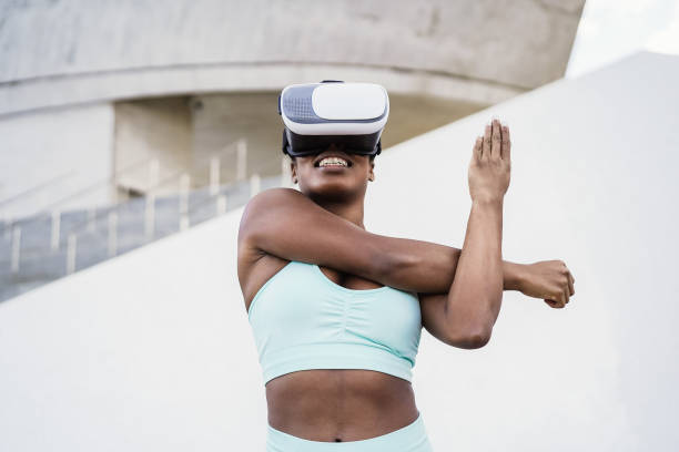 Fir african woman wearing virtual reality headset during sport workout routine - Focus on vr goggles