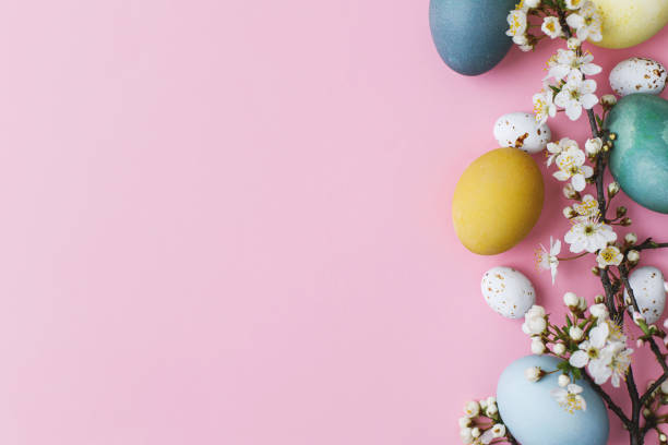 istock Happy Easter! Stylish easter eggs and flowers flat lay on pink background. Modern natural dyed colorful eggs and cherry blossom border. Greeting card template, easter background. Space for text 1356347487