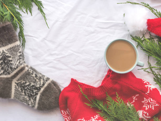 istock Winter cozy coffee mug, red sweater, warm socks on white 1356348104