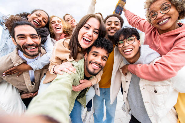 grupo de amigos multirraciales tomando retrato selfie afuera - personas felices y multiculturales sonriendo a la cámara - recursos humanos, estudiantes universitarios, amistad y concepto de comunidad - hospitable fotografías e imágenes de stock