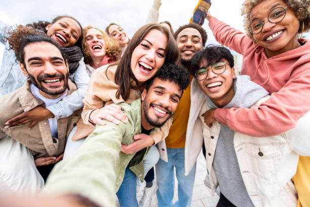 Multiracial friends group taking selfie portrait outside - Happy multi cultural people smiling at camera - Human resources, college students, friendship and community concept stock photo