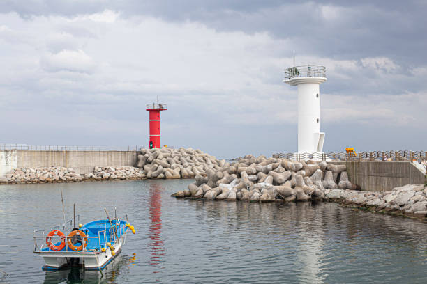 istock White and red lighthouses on seaside breakwater. South Korea. 1356349860