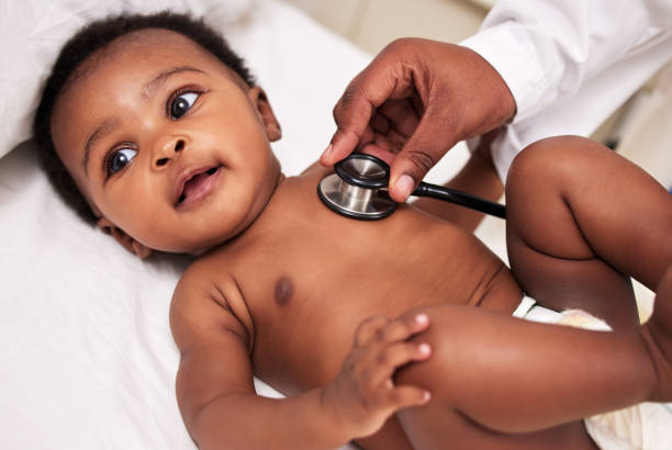 photo d’un petit bébé lors d’un examen avec un médecin dans une clinique - patient doctor african descent hospital photos et images de collection