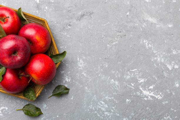istock Many red apples on colored background, top view. Autumn pattern with fresh apple above view with copy space for design or text 1356350102