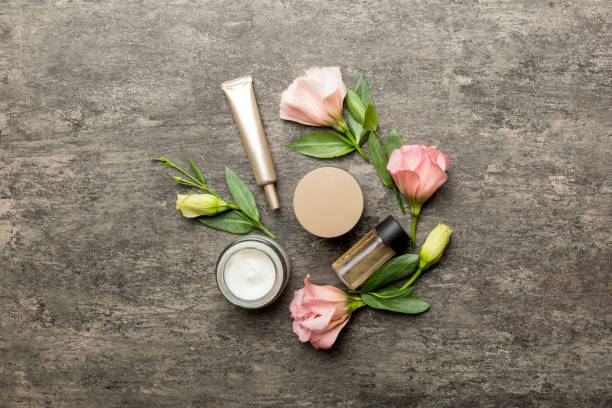 istock Composition with cosmetic products and beautiful roses on cement background. Flat lay 1356350142