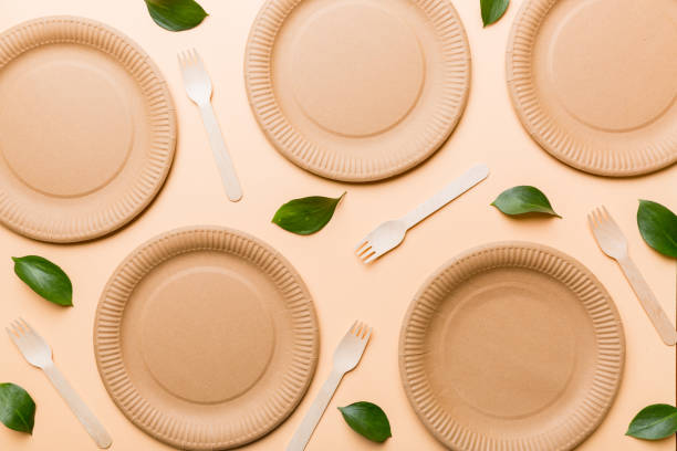 istock set of empty reusable disposable eco-friendly plates, cups, utensils on light white colored table background. top view. Biodegradable craft dishes. Recycling concept. Close-up 1356350180