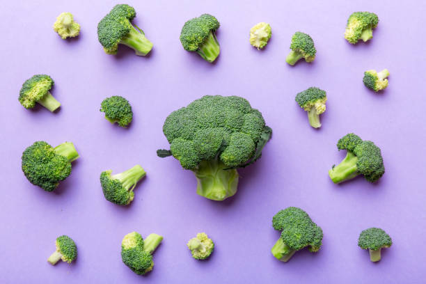 istock green fresh broccoli background close up on colored table. Vegetables for diet and healthy eating. Organic food 1356350218