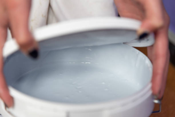 istock Woman hands opening paint can 1356352702