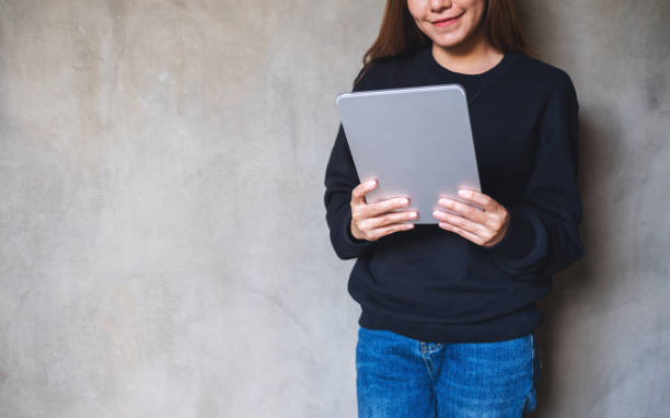 istock A young woman holding and using digital tablet 1356352722