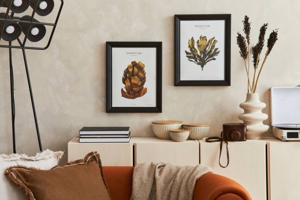 istock Creative composition of stylish living room interior with mock up poster frame, orange sofa, beige commode, coffee table and stylish personal accessories. Artistic space. Template. 1356352923