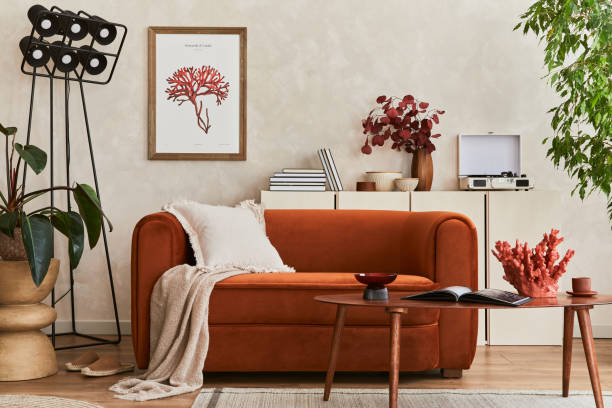 istock Creative composition of stylish living room interior with mock up poster frame, orange sofa, beige commode, coffee table and stylish personal accessories. Artistic space. Template. 1356352927