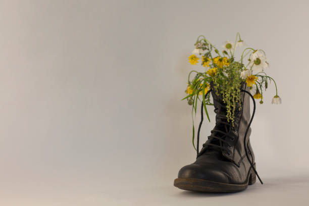 istock Wild flowers in old black boot. 1356352972