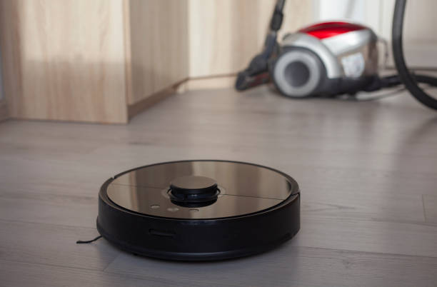 istock Robotic vacuum cleaner against old vacuum cleaner. 1356353002