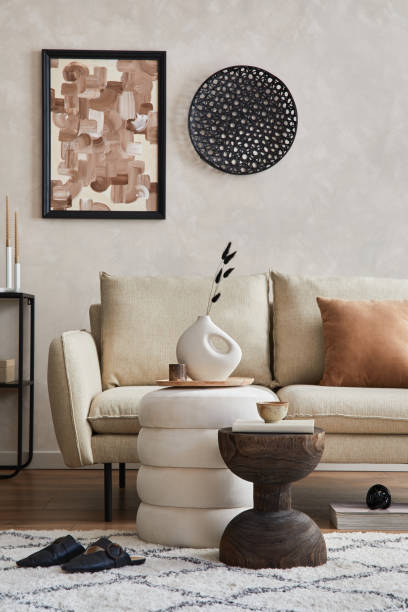 istock Elegant living room interior composition with beige sofa, black console, coffee table, pouf, mock up poster frame and creative design personal accessories. Copy space. Template. 1356355343