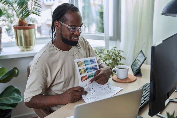 istock Successful young designer sitting at home and working with computer 1356356605