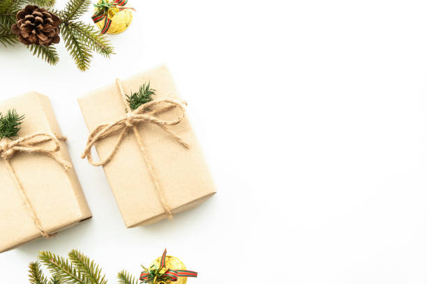 istock Beautiful Christmas background with two gift boxes, decorate with pine branch and pine cone over white background. Top view with copy space, flay lay. 1356358431