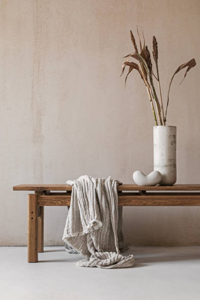 istock Creative minimalistic interior composition with elegant wooden bench. Beautiful decorations and accessories. Modern home interior design. Retro inspiration. Copy space. Structure wall. Template. 1356358825