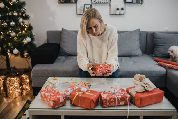 istock Woman packing presents for Christmas in boxes 1356358964