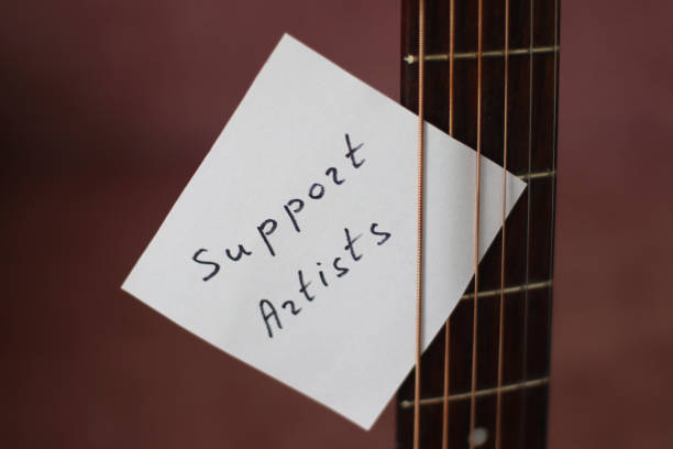 istock Support Artists Note Attached to Acoustic Guitar 1356359028